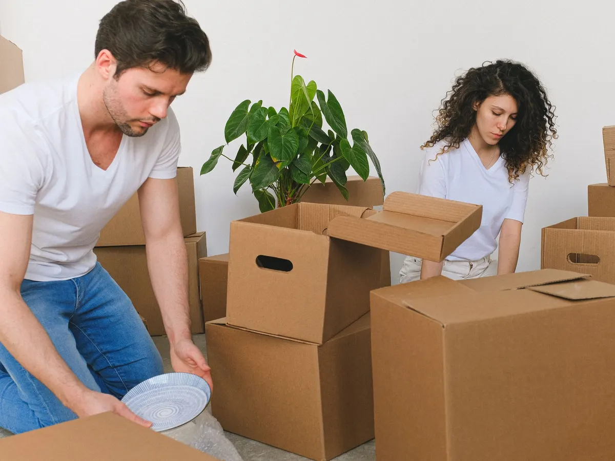 Couple unpacking cardboard boxes in a new home